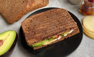 Juodos duonos paninis su avokadu ir saulėje džiovintais pomidorais